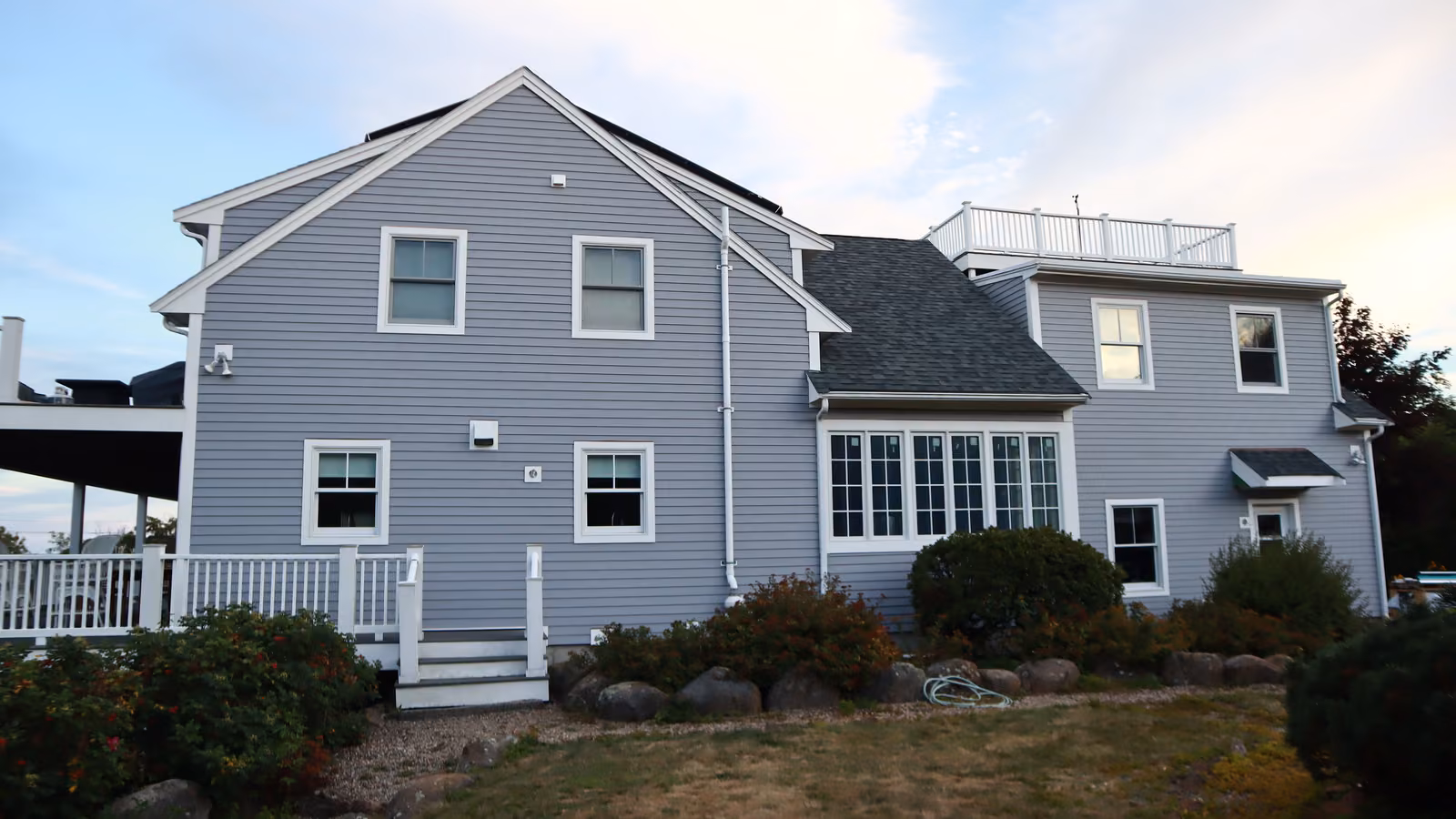 Rear elevation of a Rockport home with gray lap siding across multiple gables