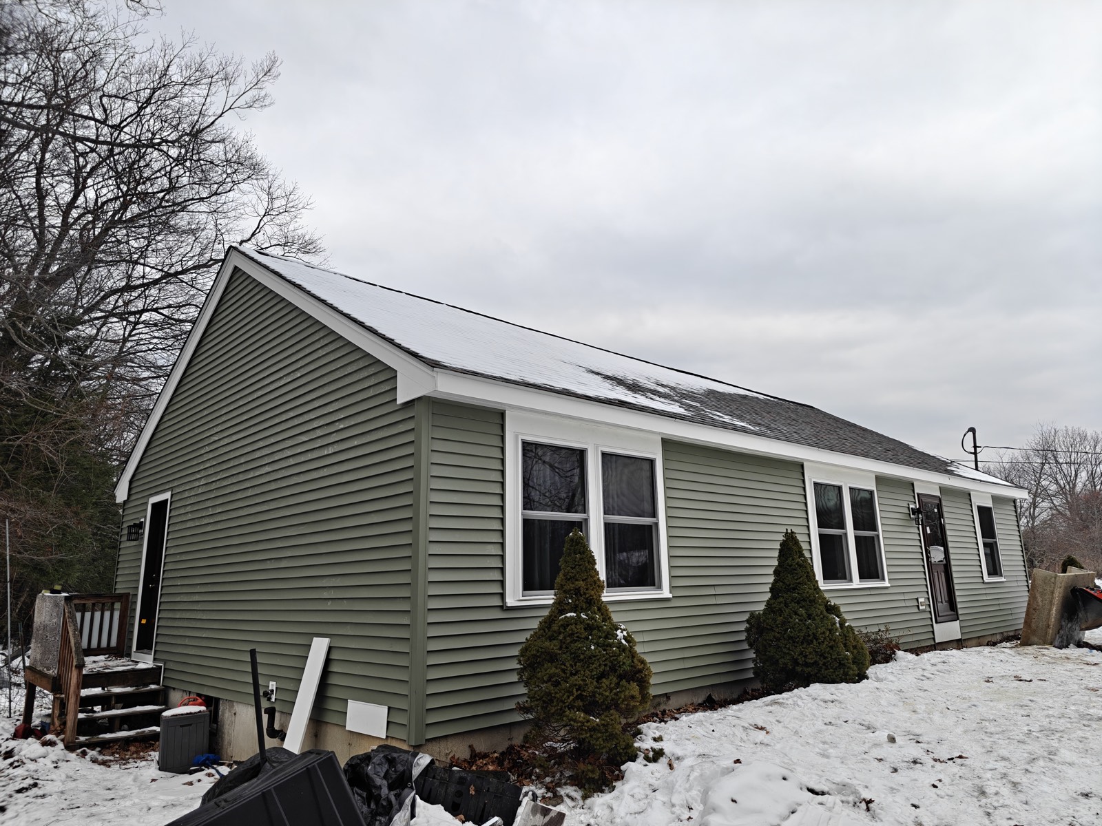 Side elevation of a sage-green ranch with clean rooflines and new siding